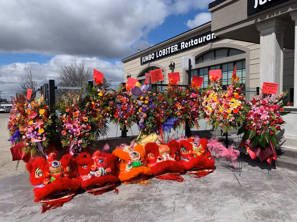 Lions resting before flower arrangements at a restaurant grand opening