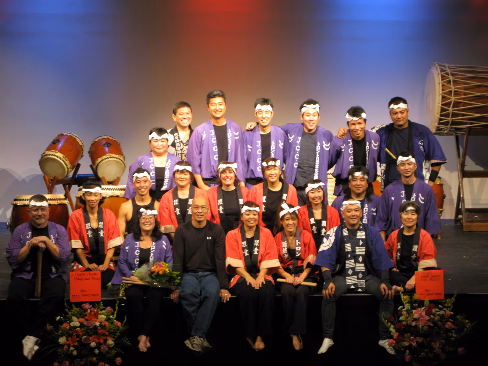 Taiko drumming group posing on stage with their drums