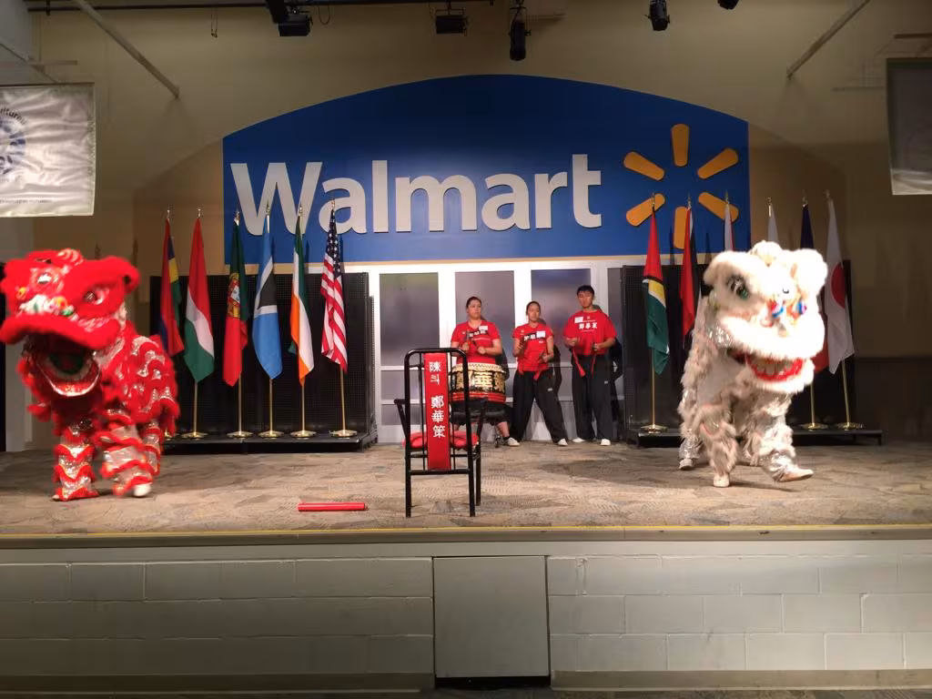 Red and white lions performing on stage in front of a Walmart banner